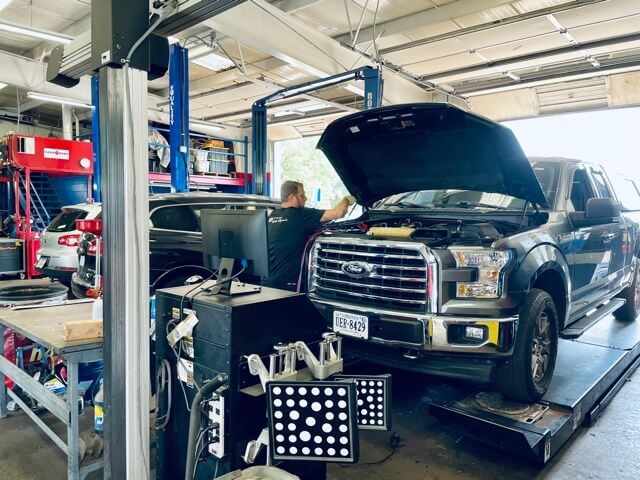 A truck in the bay at ABS Unlimited for a wheel alignment