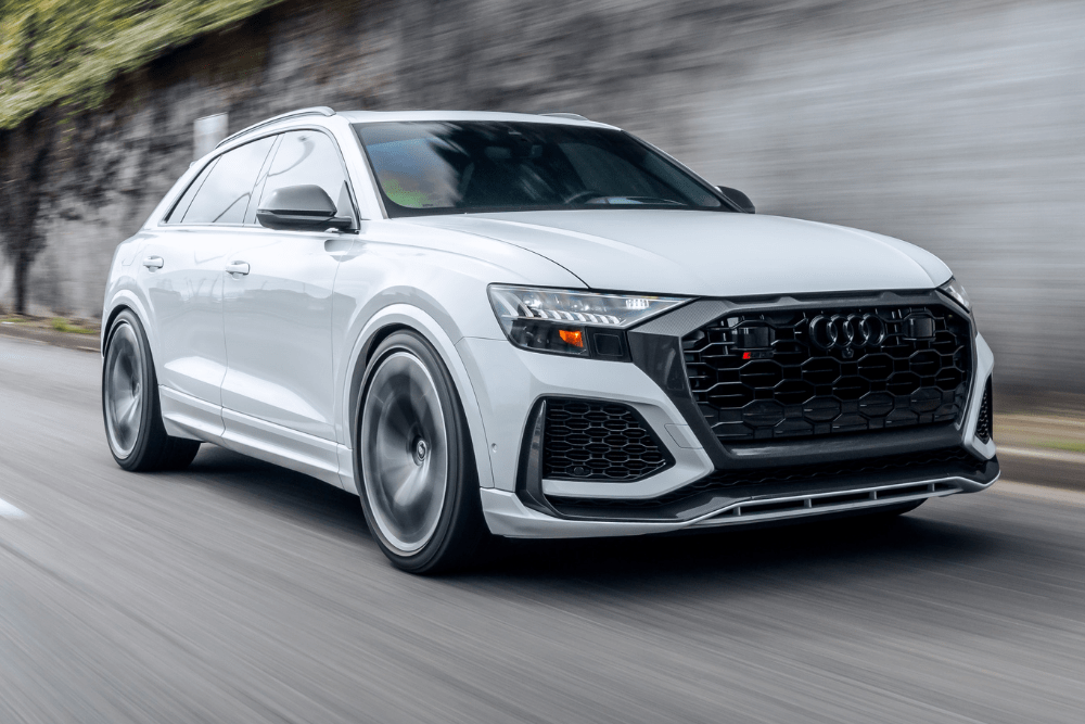fwd vs awd, auto repair in Fairfax, VA at ABS Unlimited Auto Repair. Audi RS Q8 in motion on a city street, showcasing its sleek white exterior, aggressive front grille, and black performance wheels.