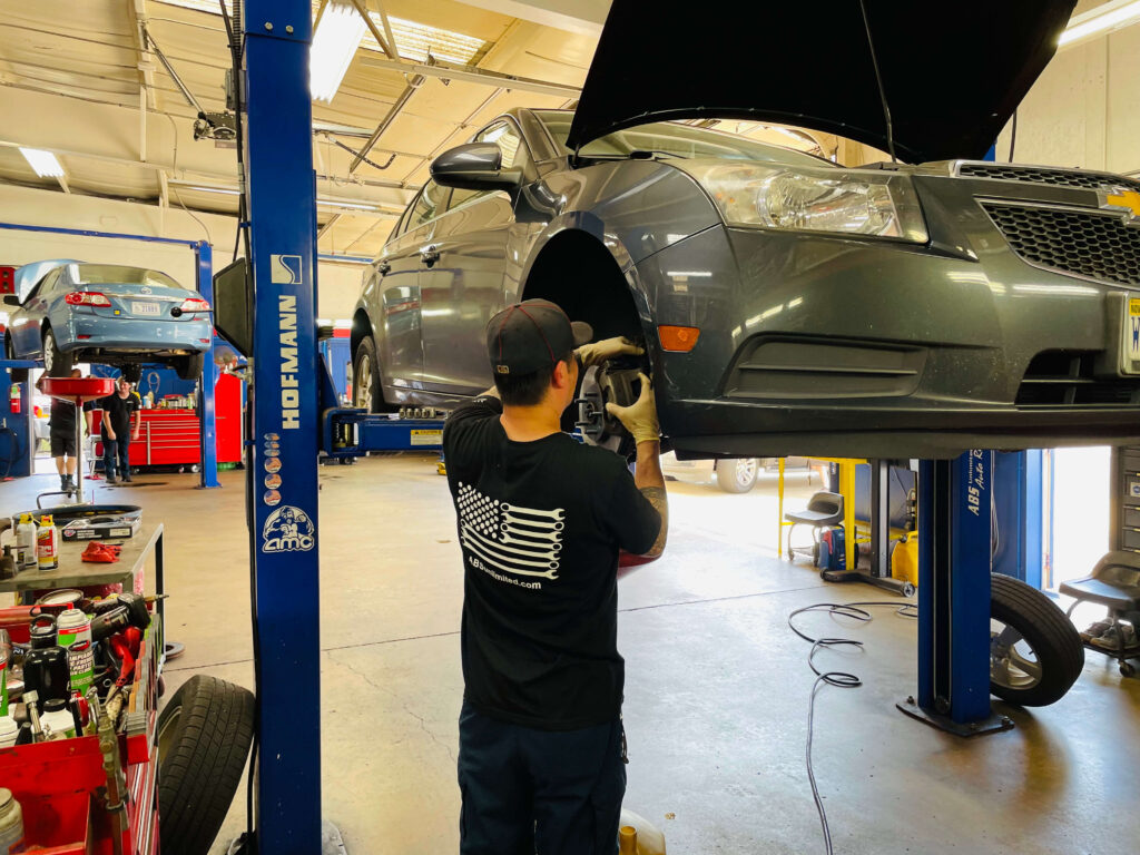 Mechanic working on elevated car